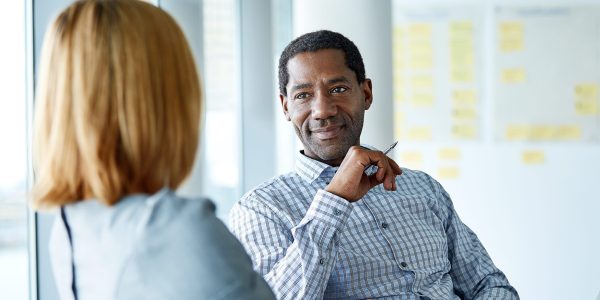 Shot of two colleagues talking together while sitting in a modern office